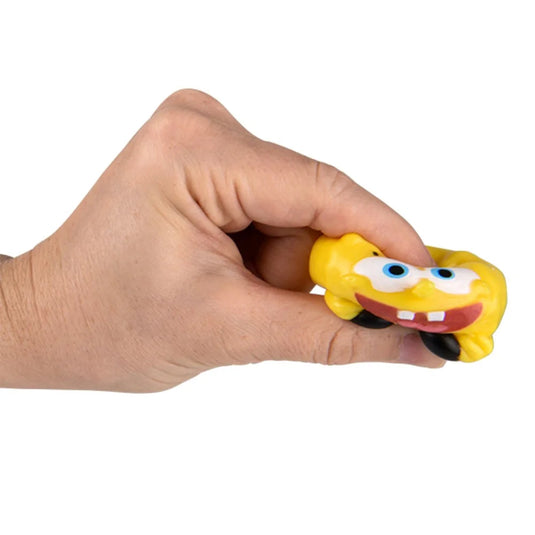 Hand holding a small yellow sponge-like character with a white background